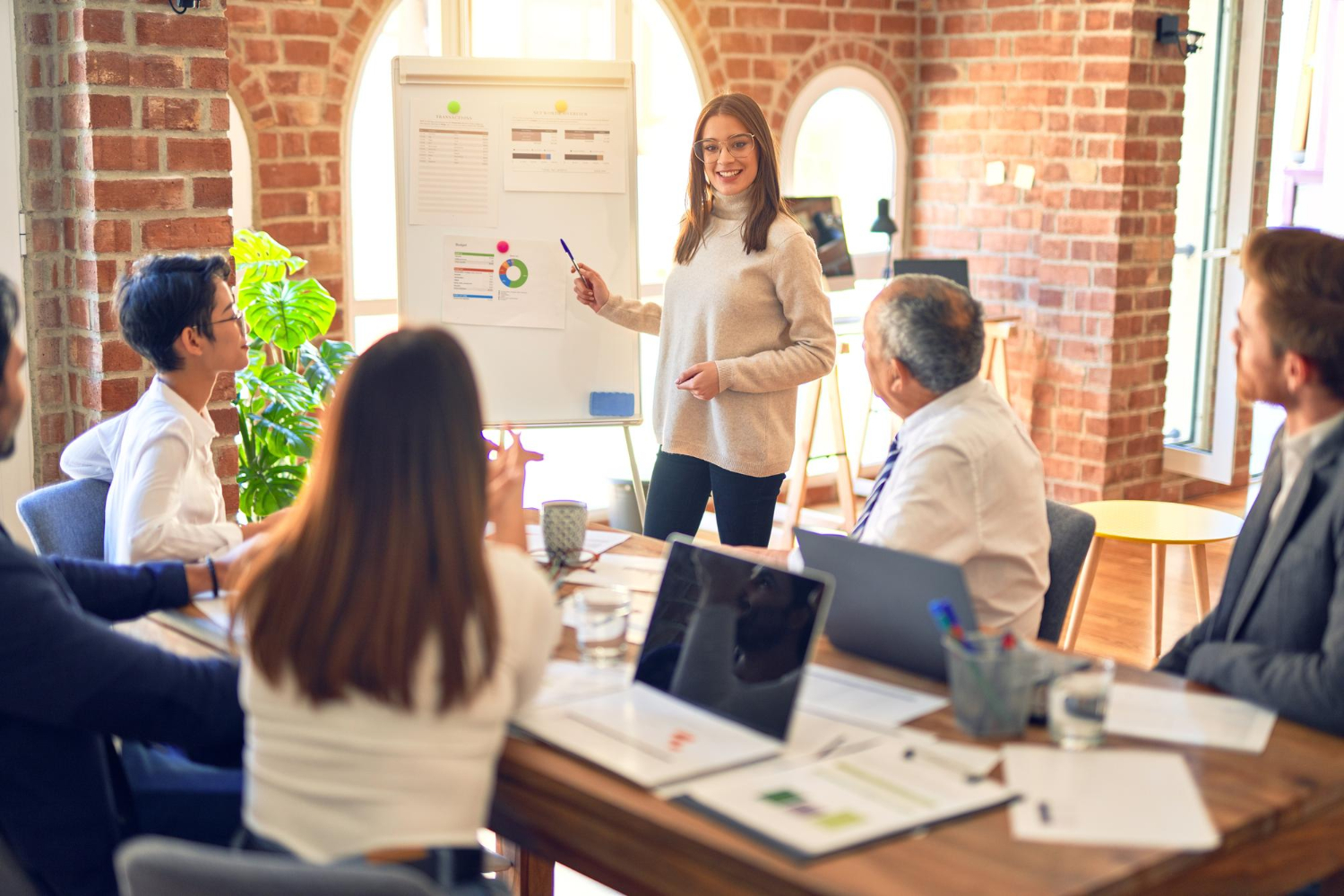 Groupe d'employés d'entreprise travaillant ensemble lors d'une réunion L'un d'eux faisant une présentation à des collègues au bureau